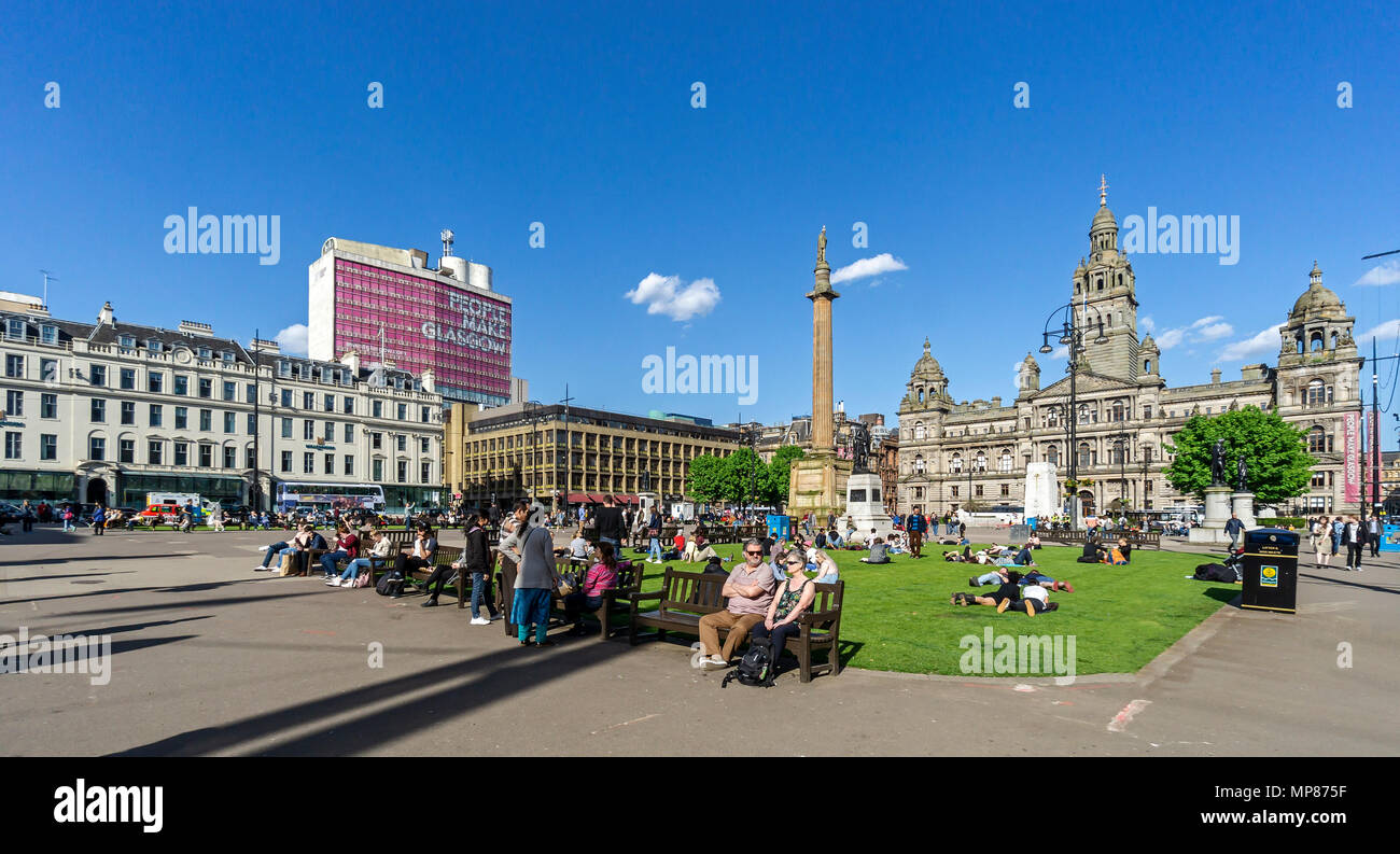 Les personnes bénéficiant de soleil d'été dans la région de George Square dans le centre-ville de Glasgow Ecosse UK avec Sir Walter Scott statue et Glasgow City Chambers Banque D'Images