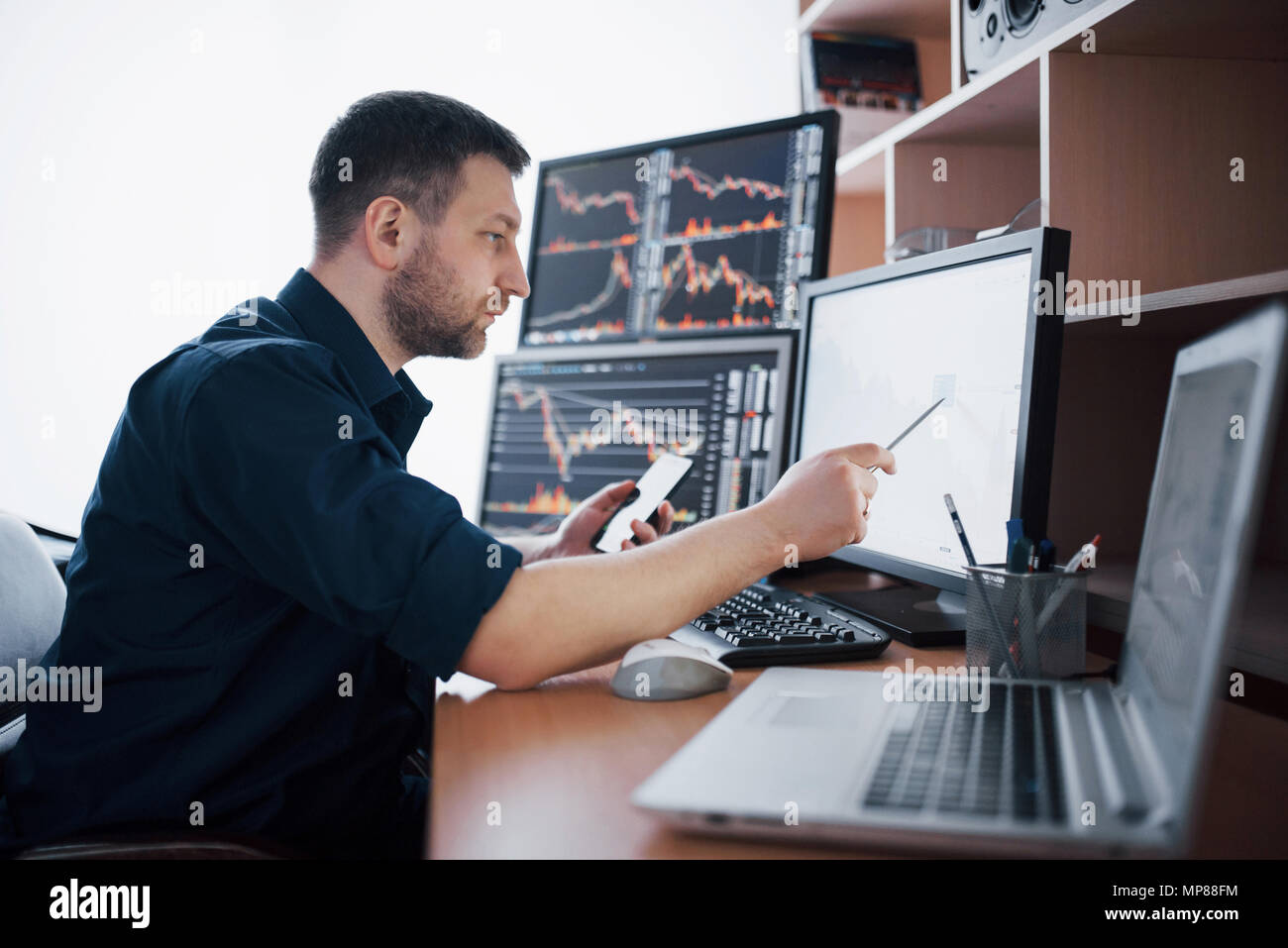 Courtier en shirt travaille dans une salle de surveillance avec des écrans. Forex Trading Bourse Finances Concept graphique. Les stocks d'affaires en ligne trading Banque D'Images