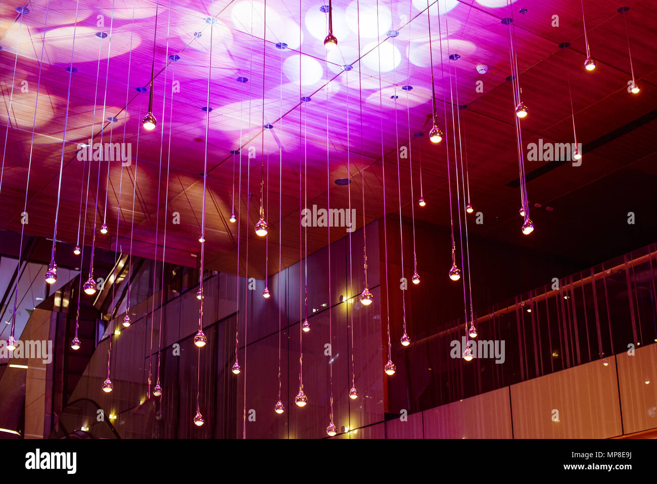 De nombreuses lampes rondes sous plafond. Dans les lampes à la mode noir brillant de l'intérieur. Les lampes blanches ou claires sur fond de couleur sombre éclat. Concept d'éclairage et de l'intérieur. Focus sélectif. L'espace pour le texte. Banque D'Images