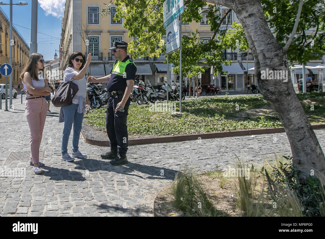 Lisbonne, Portugal, le 6 mai 2018 : un couple de touristes demandent un policier pour les directions. Banque D'Images