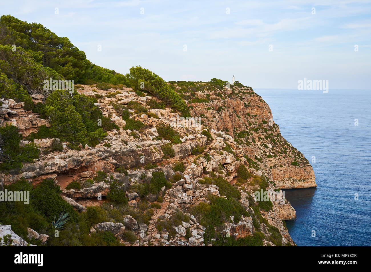 Vue panoramique de Punta de Sa Ruda mer et falaises environnantes avec phare de La Mola, près d'El Pilar de la Mola (Formentera, Iles Baléares, Espagne) Banque D'Images