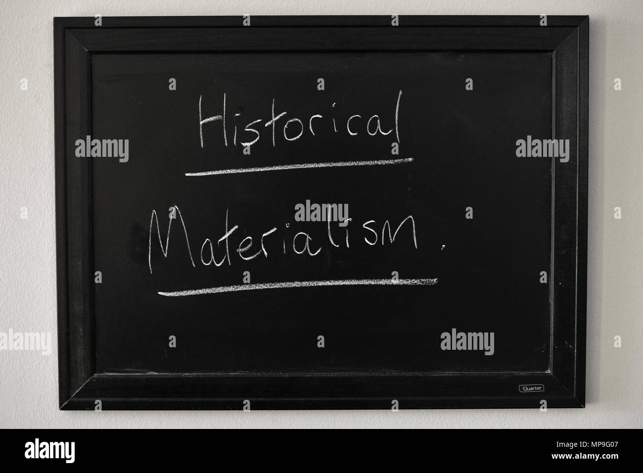 Le matérialisme historique écrit en craie blanche sur un tableau noir fixé au mur. Banque D'Images