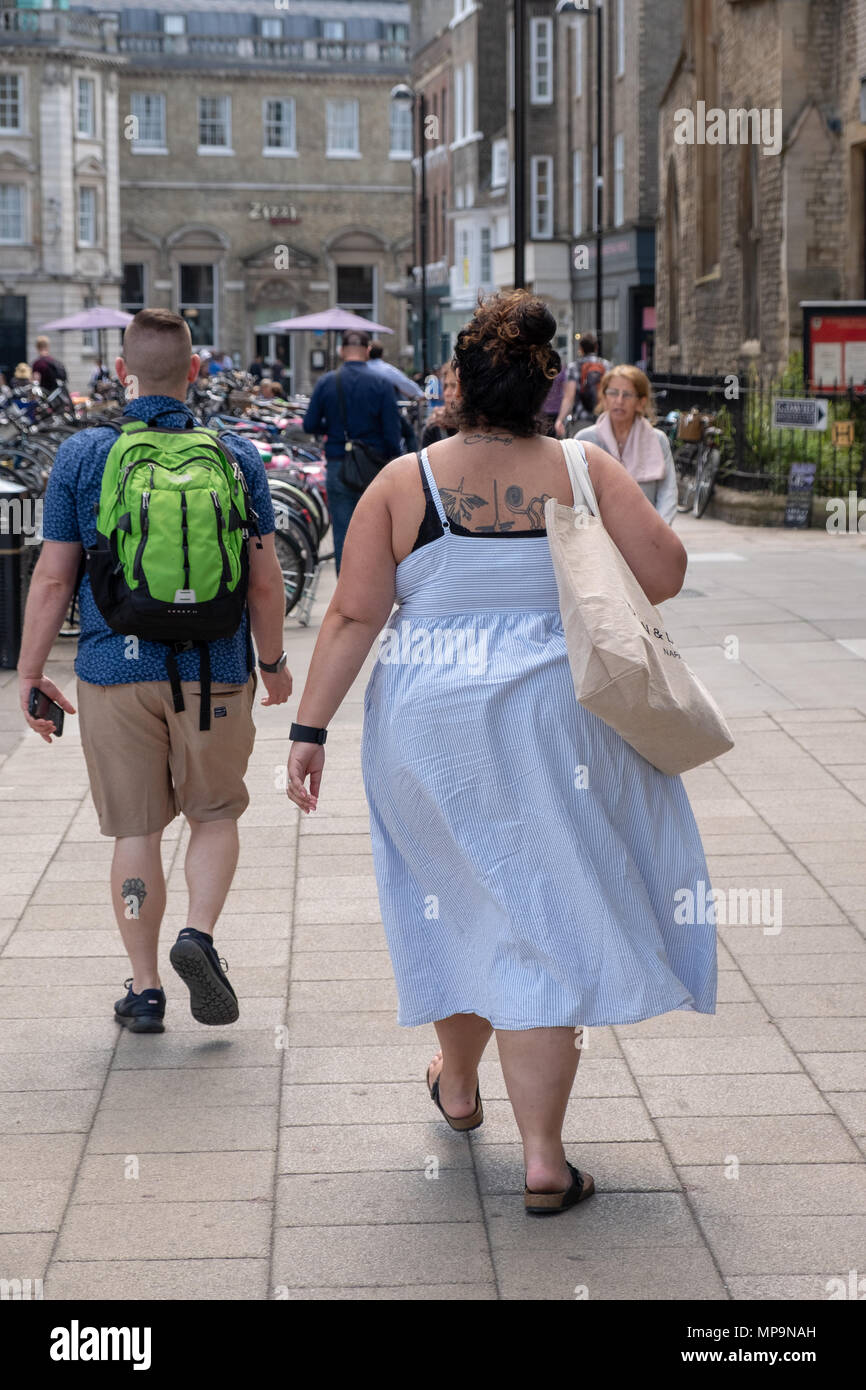Vue arrière d'un couple obèse marchant dans le centre-ville de Cambridge, au Royaume-Uni. Banque D'Images