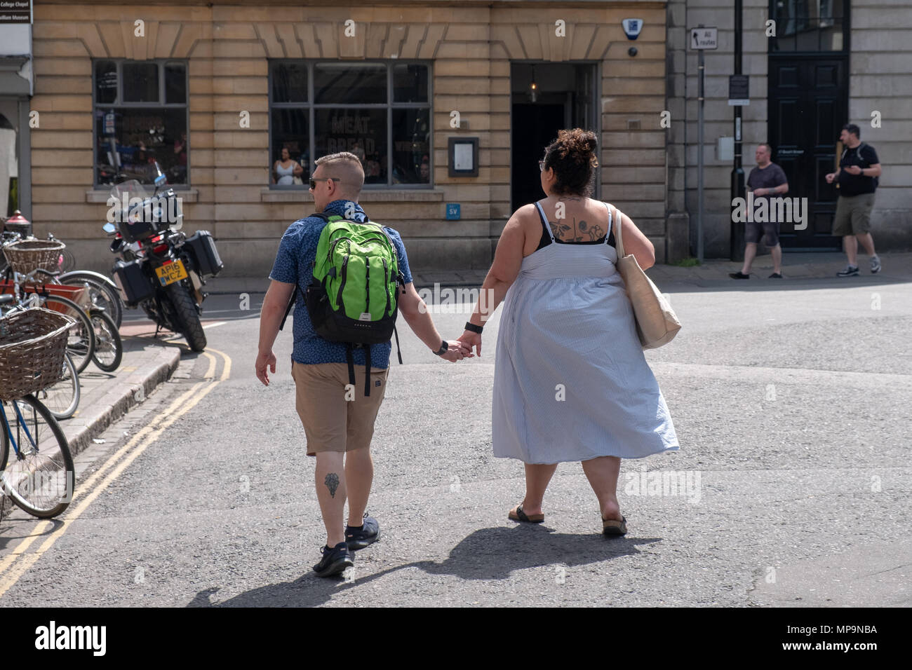 Vue arrière d'un couple obèse marchant dans le centre-ville de Cambridge, au Royaume-Uni. Banque D'Images