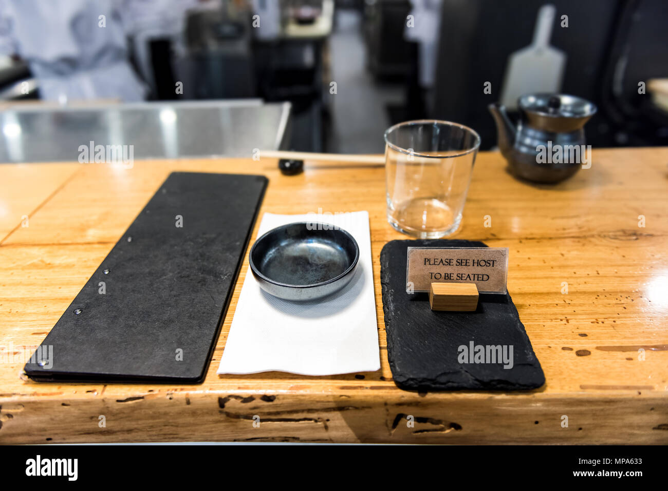 Style traditionnel japonais, sushi bar en bois asiatique restaurant comptoir sign, menu, bol, verre, serviette vide réglage gros plan personne Banque D'Images