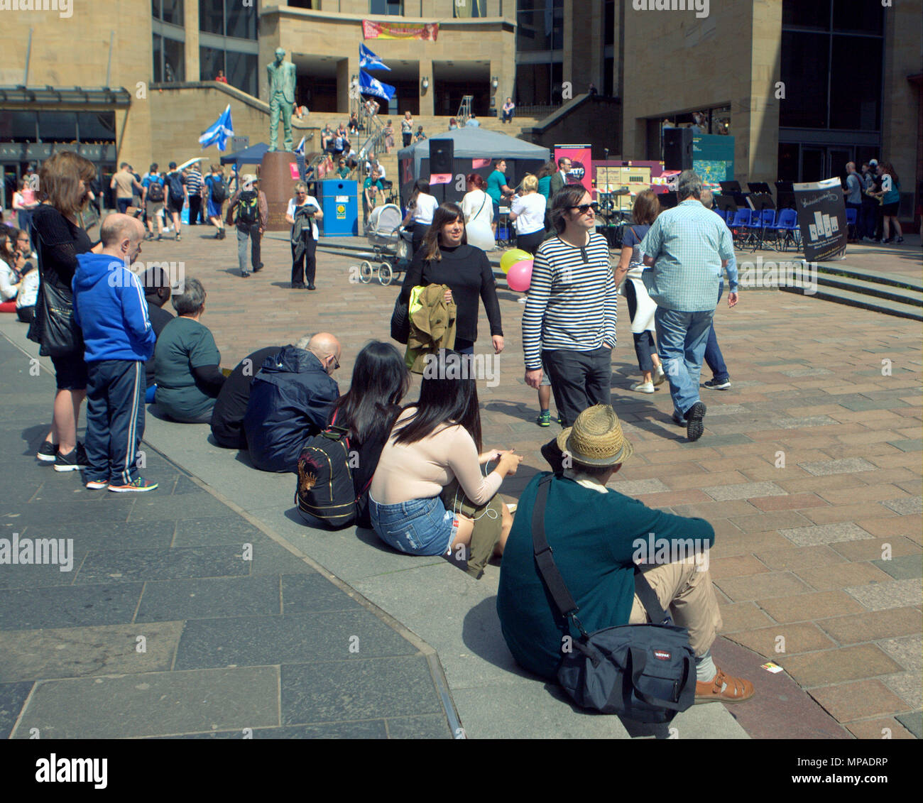Les habitants et les touristes assis le soleil brille, beau temps sur la salle de concert comme suit en haut de la rue Buchanan bas de Sauchiehall Street Banque D'Images