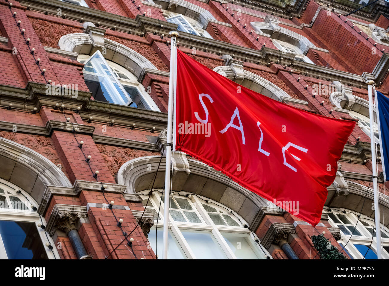 Shopping, vente drapeau rouge volant à Arnotts grand magasin, façade de bâtiment en grès brun, sur Henry Street. Dublin, Irlande, UE. Vue rapprochée, angle bas Banque D'Images