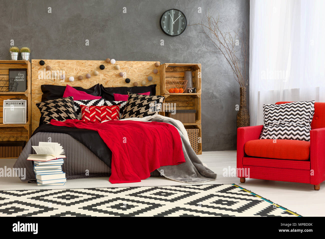 Chambre avec grand lit, meubles, tapis et modèle Fauteuil rouge Photo Stock  - Alamy