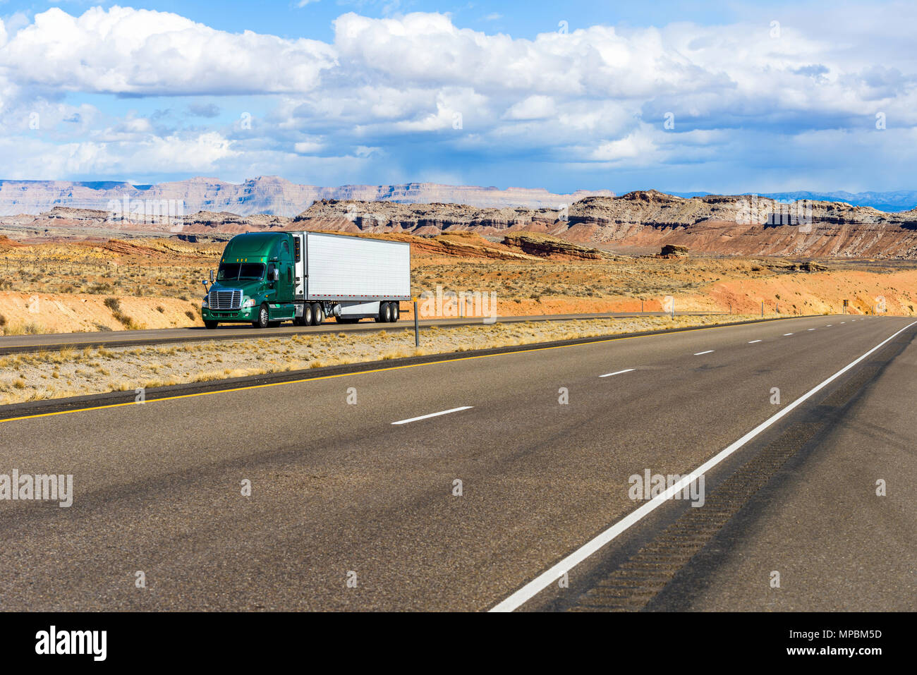 L'Autoroute du désert - un camion semi-remorque roulant sur l'autoroute Interstate I-70 dans des terres désertiques, Utah, USA. Banque D'Images