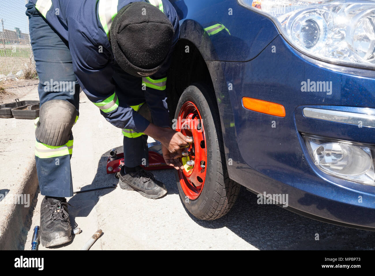 Un technicien de service ou de la personne l'installation d'une roue de secours ou pneu. Banque D'Images