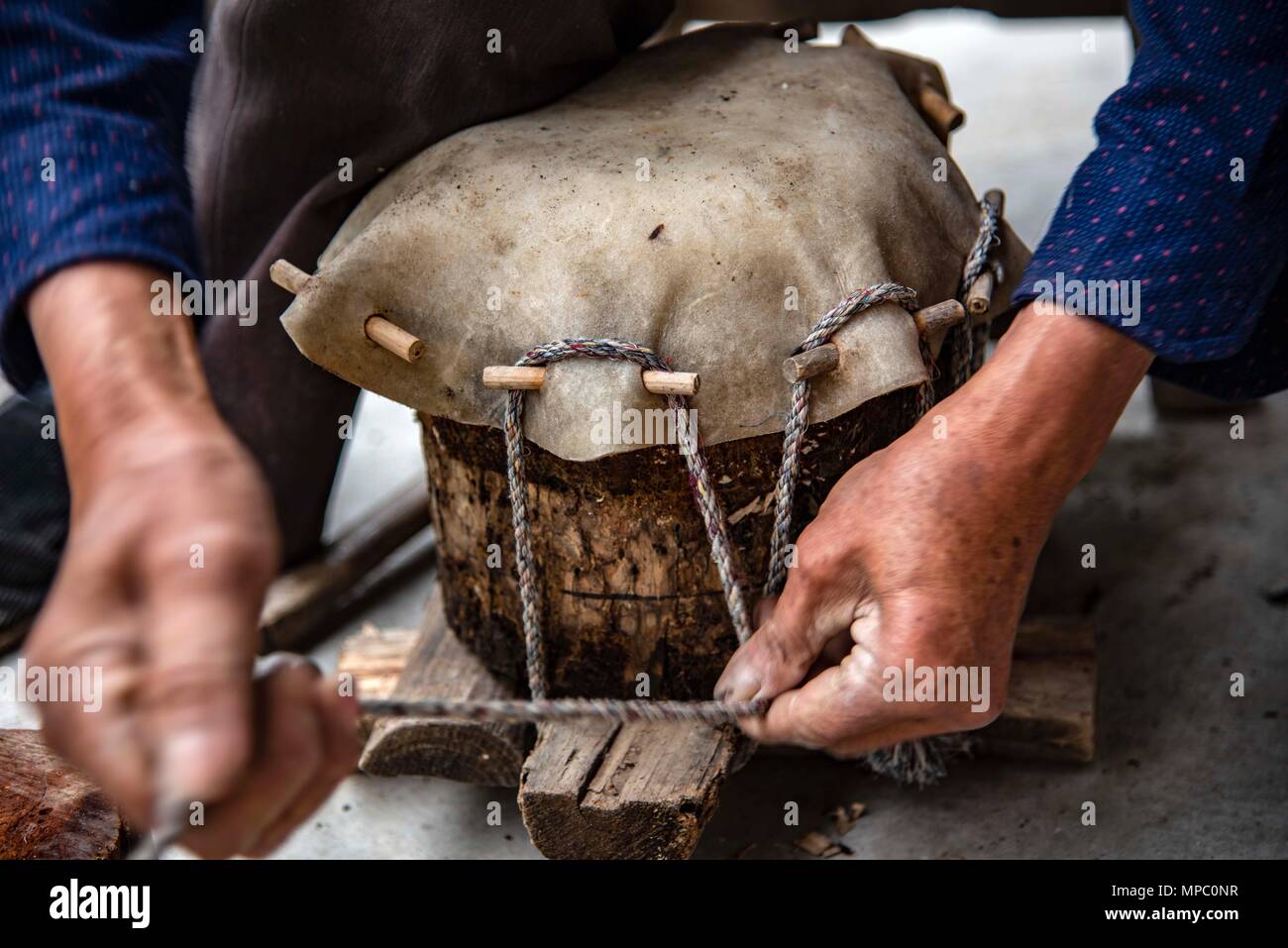 (180522) -- SHENNONGJIA, 22 mai 2018 (Xinhua) -- Kaixue Dingtang Wu fait un tambour à sa cour dans Village de Shennongjia Longtan, le centre de la Chine, la province du Hubei, le 21 mai 2018. Kaixue Wu, qui est de 75 ans, a commencé à apprendre la fabrication de tambours Dingtang lorsqu'il avait 13 ans. La fabrication de tambours Dingtang a besoin des ressources naturelles de la forêt de Shennongjia et exige aussi des techniques de haut niveau. Wu fait 100 plus de la batterie dans un an et sa renommée s'est répandue très loin. (Xinhua/Du Huaju) (zwx) Banque D'Images