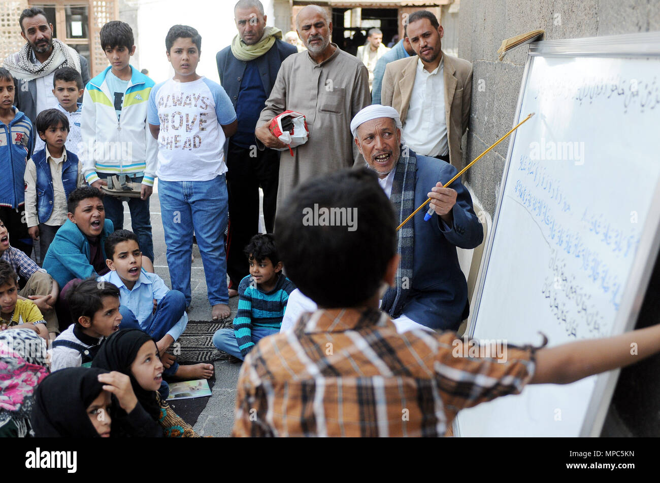 Sanaa, Yémen. 22 mai, 2018. Un bénévole yéménite enseigne aux enfants l'alphabet arabe dans des cours gratuits dans une mosquée pendant le mois de Ramadan à Sanaa, Yémen, le 22 mai 2018. Credit : Mohammed Mohammed/Xinhua/Alamy Live News Banque D'Images