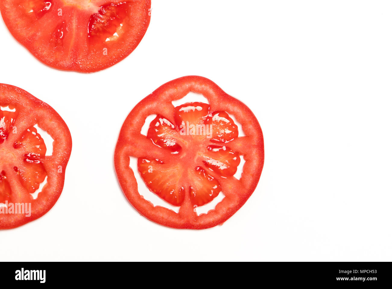 Tranche de tomate mûre rouge Vue de dessus isolé, concept fruits et légumes Banque D'Images