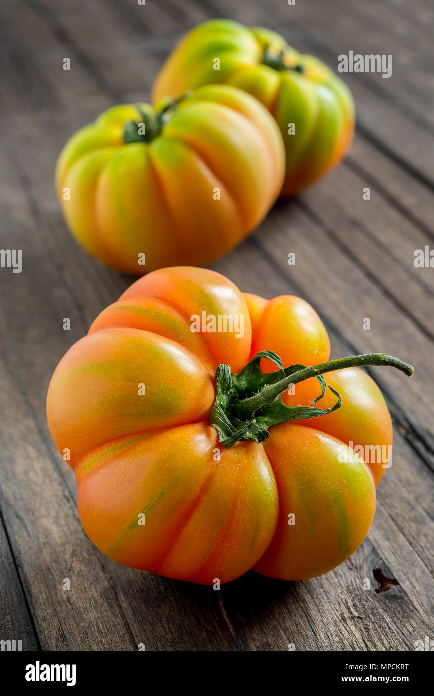 Tomates non mûres marmande sur table en bois Banque D'Images