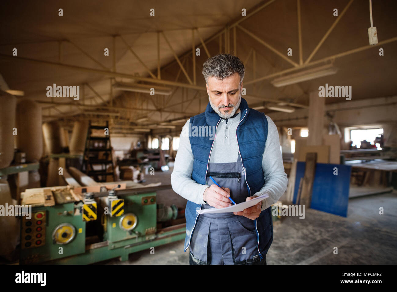 Un homme travailleur dans l'atelier de menuiserie, à faire des plans. Banque D'Images