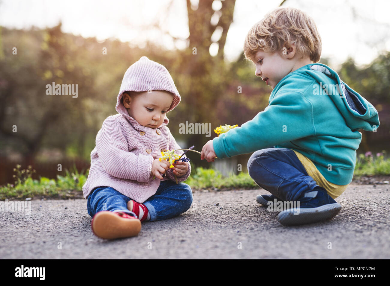 Un bébé garçon et fille à l'extérieur sur un ressort à pied Photo Stock -  Alamy