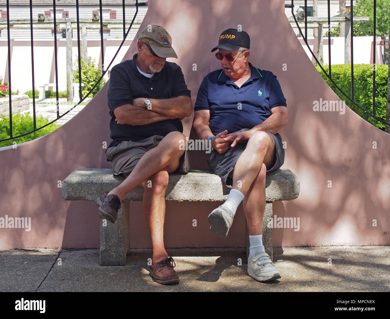 Un atout partisan et ami chit-chat sur un banc en béton, Saint Augustine, Floride, USA, 2018, © Katharine Andriotis Banque D'Images