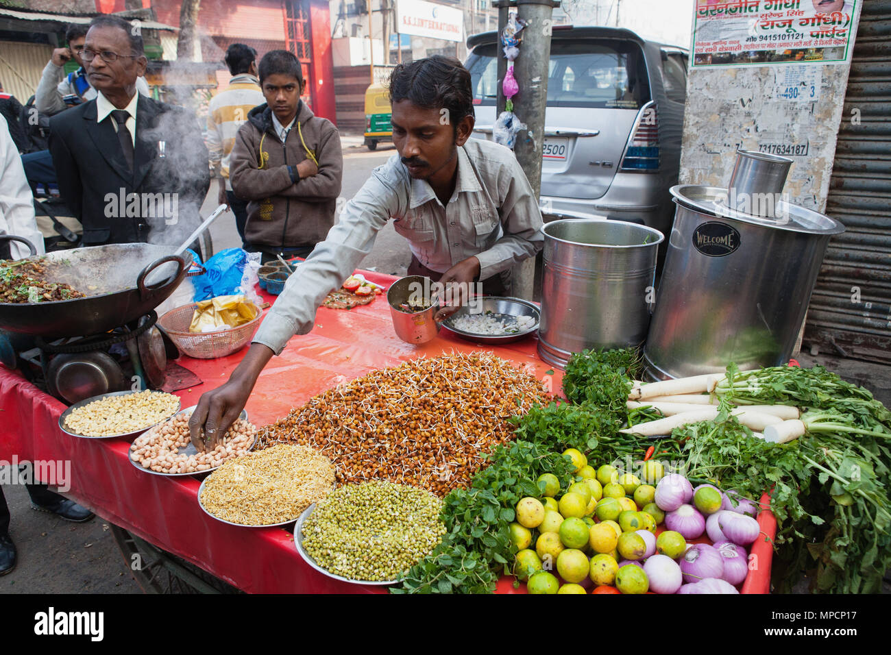 L'Inde, Uttar Pradesh, Lucknow, un vendeur prépare un casse-croûte végétarien y compris les haricots mungo à srouts son road-side stall. Banque D'Images