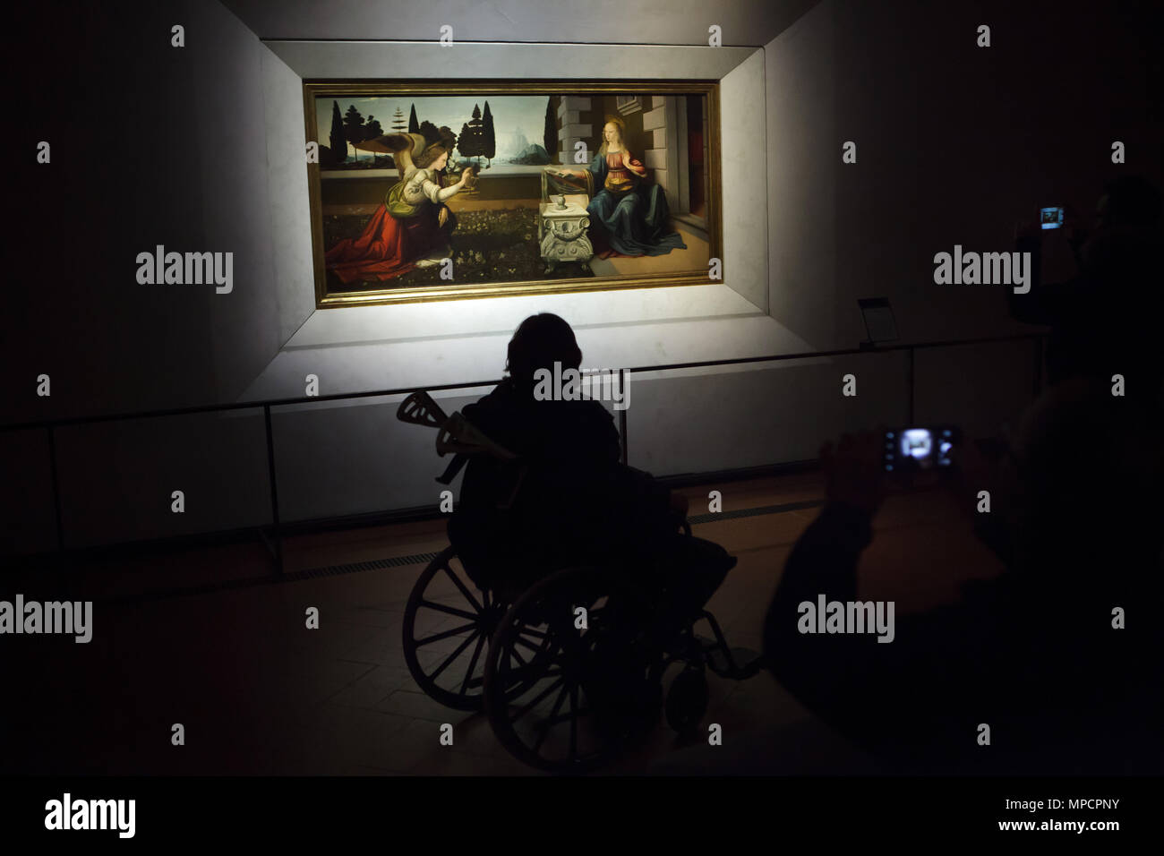 Personne handicapée dans le fauteuil roulant en face de l'annonciation peinture (1472-1475) par le peintre italien de la Renaissance Léonard de Vinci affichés dans la galerie des Offices (Galleria degli Uffizi), à Florence, Toscane, Italie. Banque D'Images