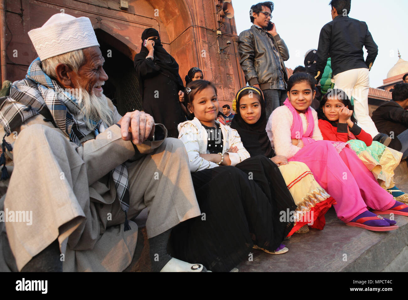 L'Inde, New Delhi, les filles musulmanes s'asseoir sur les marches de l'entrée de la Jama Masjid dans la vieille ville de Delhi. Banque D'Images