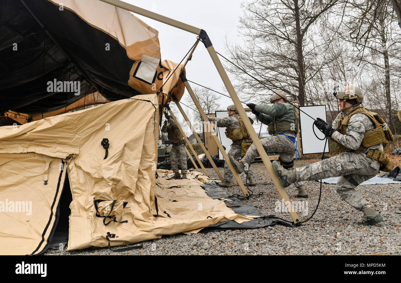 Aviateurs affecté à la 435ème Groupe d'intervention d'urgence travaillent ensemble pour construire une tente pendant l'exercice austère Forge sur base aérienne de Ramstein, en Allemagne, le 1 février 2017. Au cours de l'exercice, les aviateurs planifié que l'équipement serait utilisé et qui serait aller, préparé l'équipement et de personnel, traitée par le 86e Escadron de préparation logistique de l'installation de la cellule de préparation au déploiement, et mis en place des tentes et de l'équipement déployé dans une simulation de l'emplacement. Le CRG 435 ont participé à l'exercice d'exercer leur capacité de déployer dans un délai de 72 heures. (U.S. Photo de l'Armée de l'air par la Haute Airman Tryphena Ma Banque D'Images