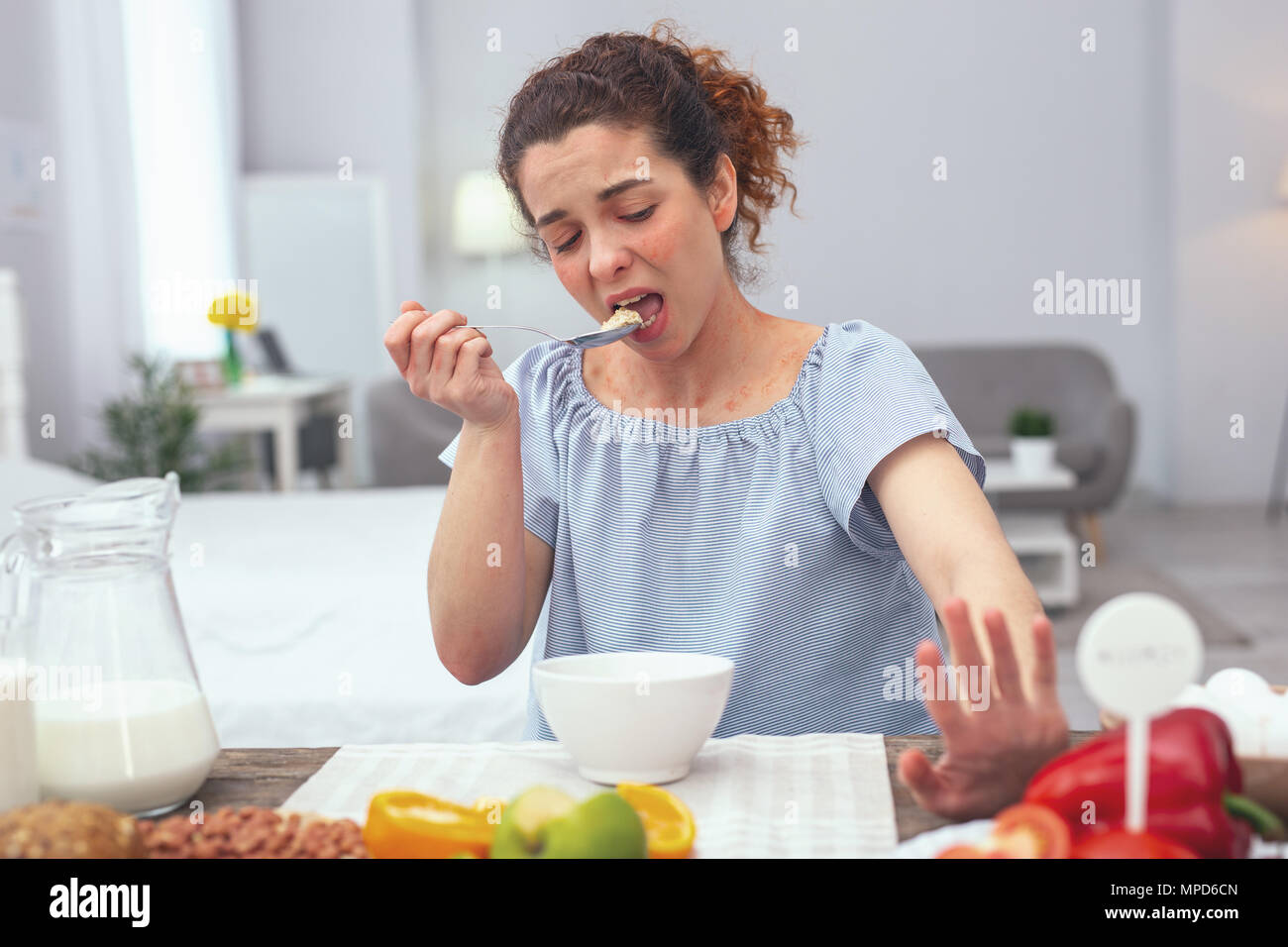 Jeune femme au foyer d'éviter de manger des légumes crus Banque D'Images