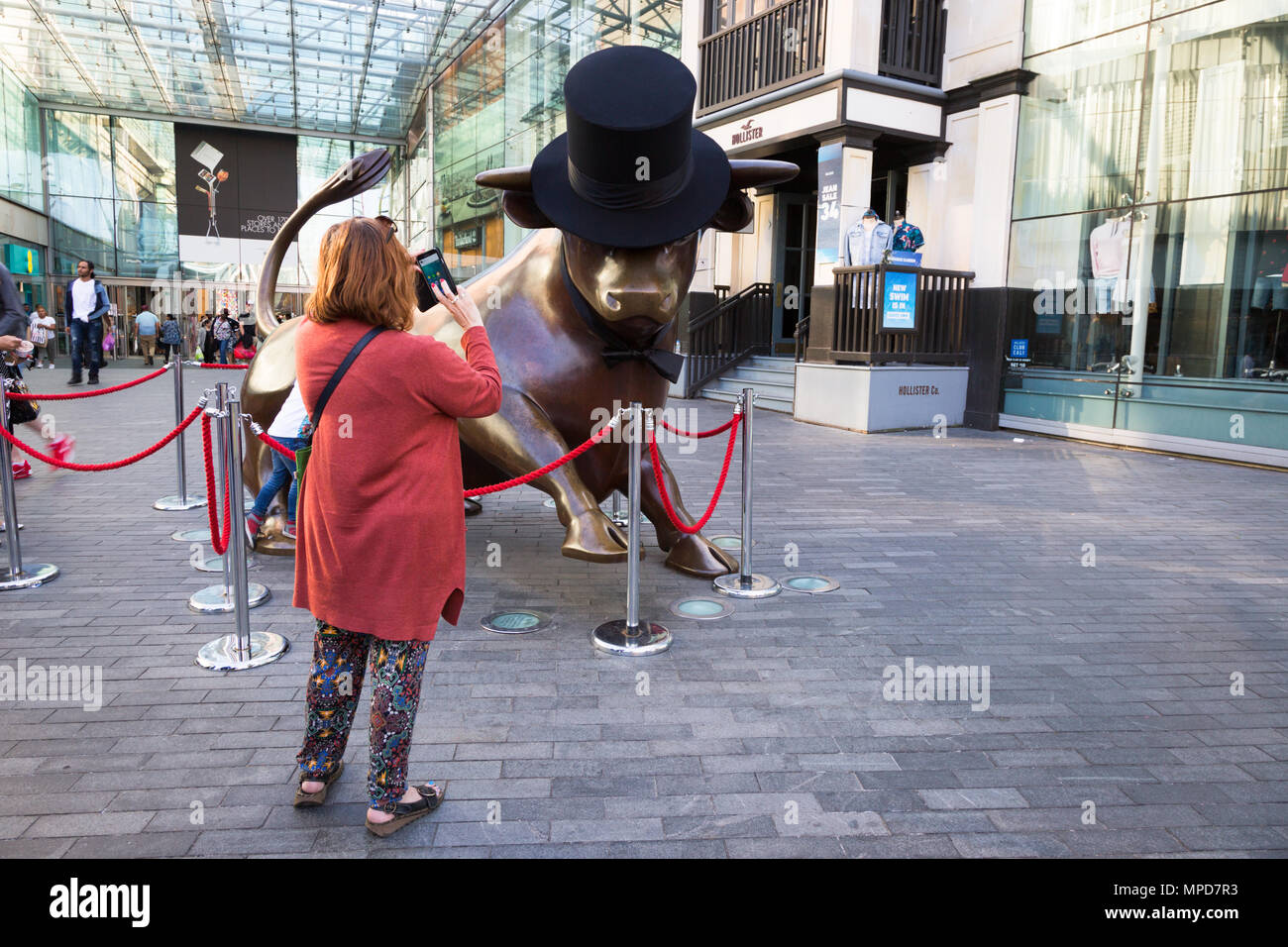 Femme de prendre une photo de la statue de taureau dans les arènes Birmingham UK Banque D'Images