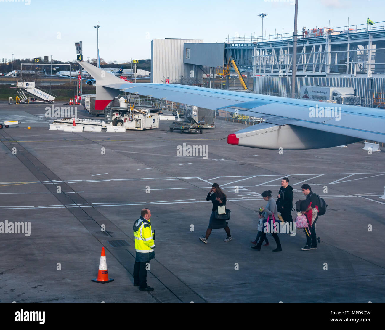 Vue depuis la fenêtre Plan de ciel ponts et aile d'avion, l'aéroport d'Édimbourg, Écosse, Royaume-Uni avec les passagers à bord de l'aire de marcher à travers airplane Banque D'Images