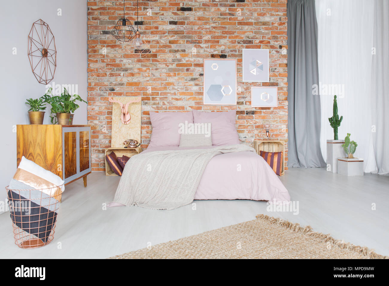 Style industriel chambre avec mur de briques et accessoires en cuivre Banque D'Images