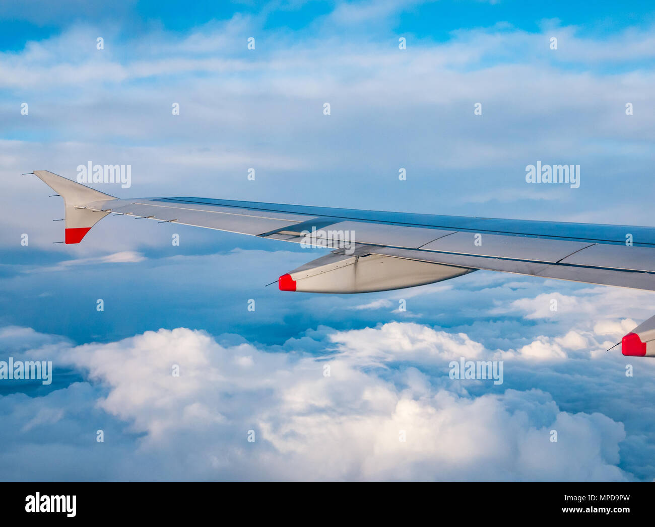 British Airways Airbus 319 aile d'avion vu d'avion en vol au-dessus de la fenêtre de puffy et fins nuages et ciel bleu clair en Royaume-Uni Banque D'Images