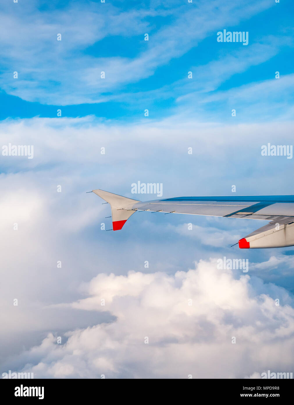 British Airways Airbus 319 aile d'avion vu d'avion en vol au-dessus de la fenêtre de puffy et fins nuages et ciel bleu clair en Royaume-Uni Banque D'Images