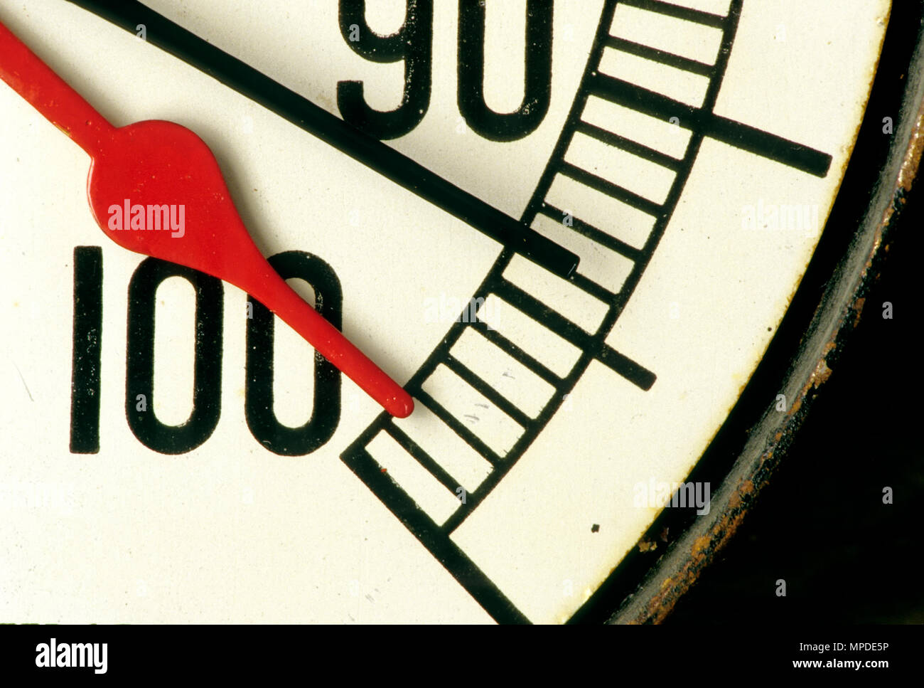 Manomètre vieux classique, rouge et les mains noires, atteignant presque 100 % 'sous pression'', vue partielle. Banque D'Images