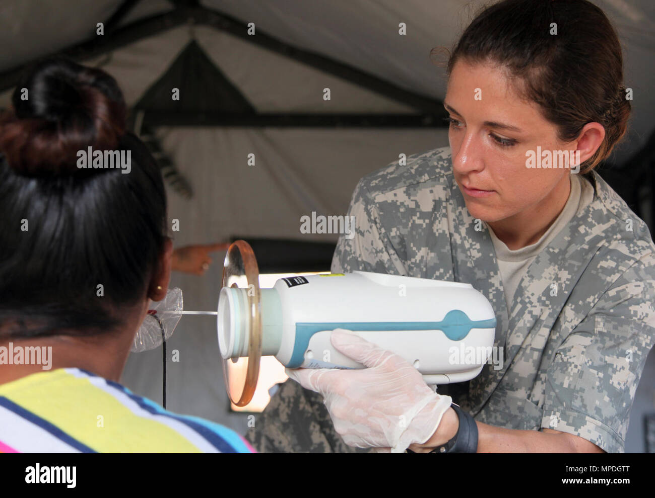 Le Sgt. Samantha Miller, de l'Army National Guard Utah Medical permet d'effectuer une x-ray sur une femme avant son examen dentaire à Ladyville, Belize, le 9 avril 2017. C'est la première des trois manifestations médicales qui sont prévues en 2017 au-delà de l'horizon du Belize. Au-delà de l'Horizon est un partenariat entre l'armée américaine, les Forces de défense et de Belize Belize plusieurs organismes du gouvernement qui sera composé de cinq projets de construction et deux autres événements de service médical dans les districts de Belize, Cayo et Stann Creek. Banque D'Images