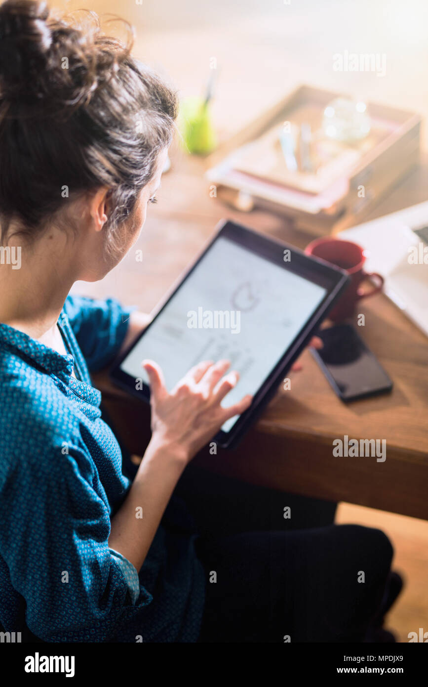 Vue de dessus. Une femme à l'aide d'une tablette numérique Banque D'Images