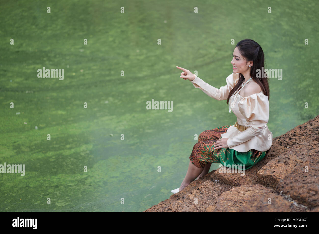 Belle femme inThai costume traditionnel est orienté près de l'étang Banque D'Images