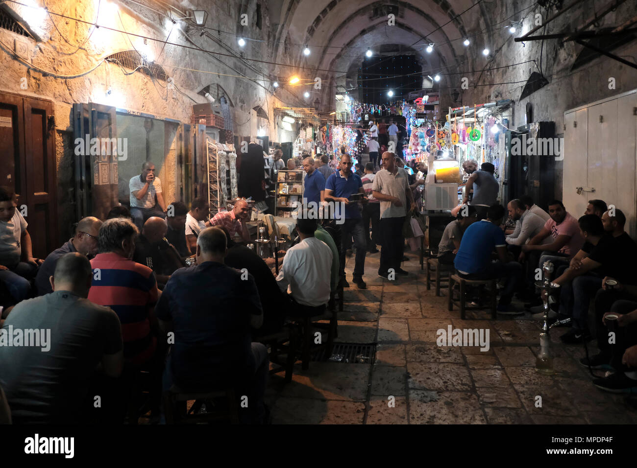 Israël, Jérusalem. 22 mai, 2018. Les Palestiniens se sont rassemblés dans un café et fumer narguilés après leur jeûne du Ramadan tous les jours au coucher du soleil à l'allée de la marché des marchands de coton - Al-Qattanin qui mène au Mont du Temple dans le quartier musulman de la vieille ville de Jérusalem de l'est Israël. Les musulmans du monde entier observer un mois de jeûne pour commémorer la première révélation du Coran à Mahomet selon la foi islamique. Banque D'Images