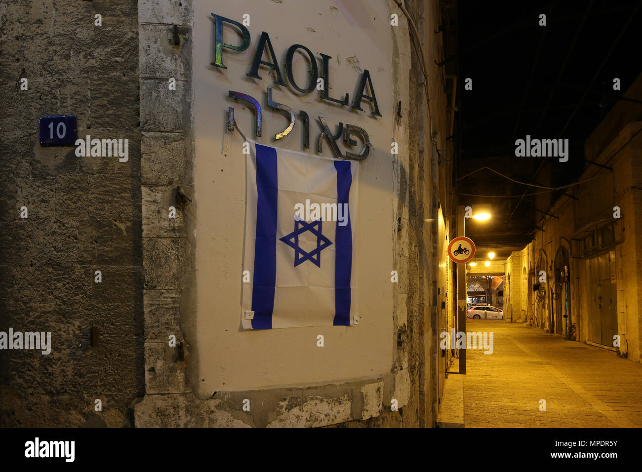 Jaffa, Israël - 14 mai 2018 : Nuit dans une ruelle de la vieille ville de Jaffa, en Israël. Au premier plan, le drapeau national israélien est attaché à un Banque D'Images