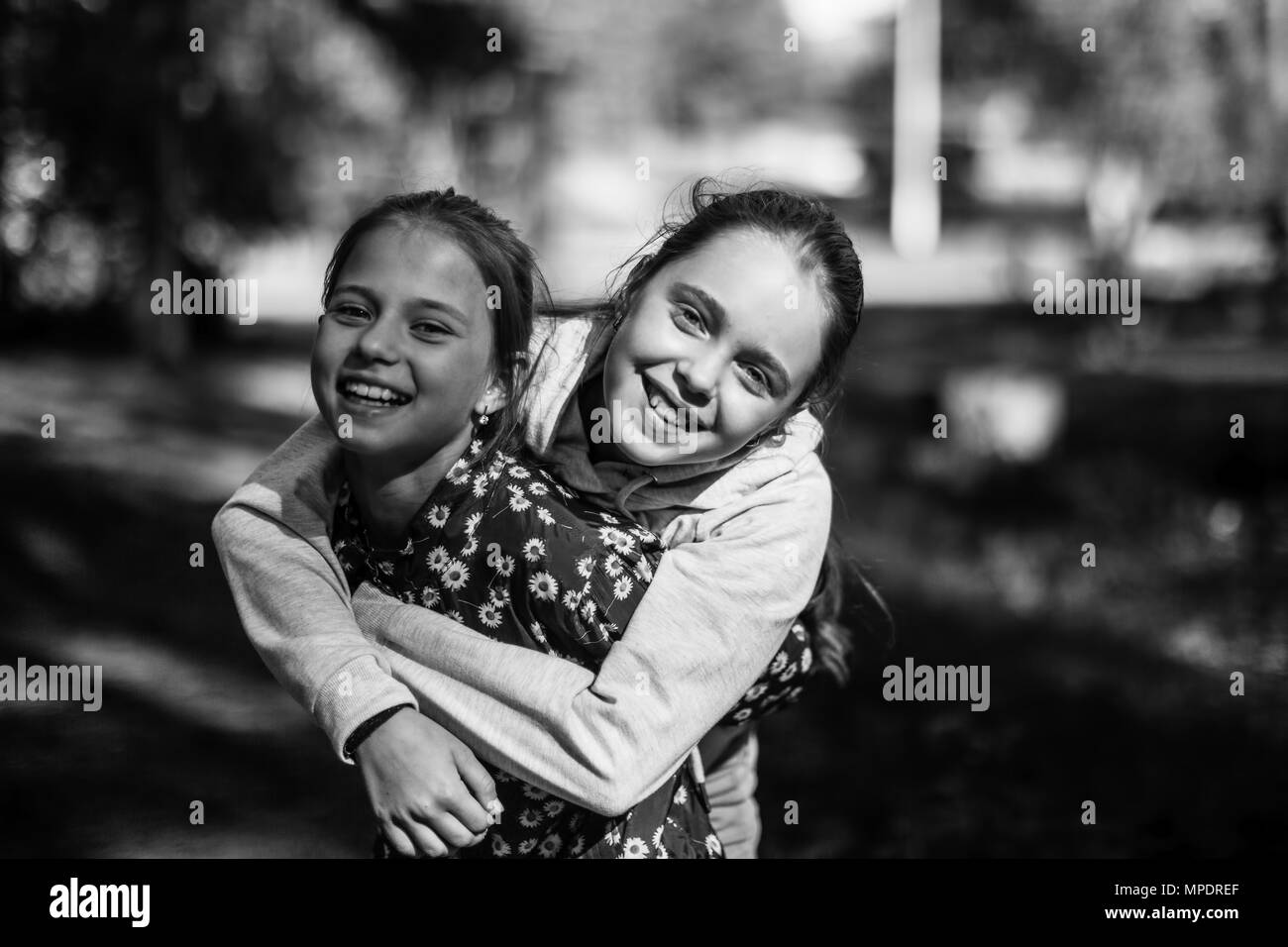 Deux soeurs filles adolescents s'amusant à l'appareil photo. Photo en noir et blanc. Banque D'Images