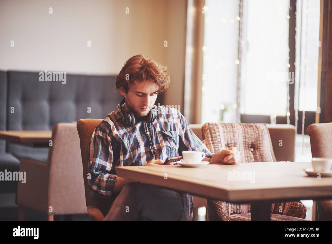 Homme heureux propriétaire de café confortable se réjouissent de propre succès alors qu'il était assis avec touch pad à table à manger, male holding digital tablet et pense à quelque chose de bien pendant le déjeuner in coffee shop Banque D'Images