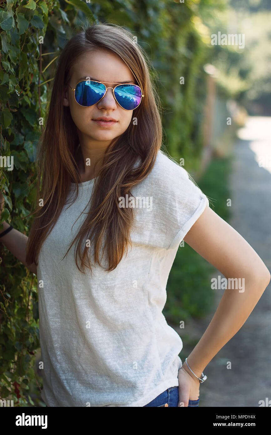 Beautiful smiling girl en blouse blanche, contre green park de l'été. Banque D'Images