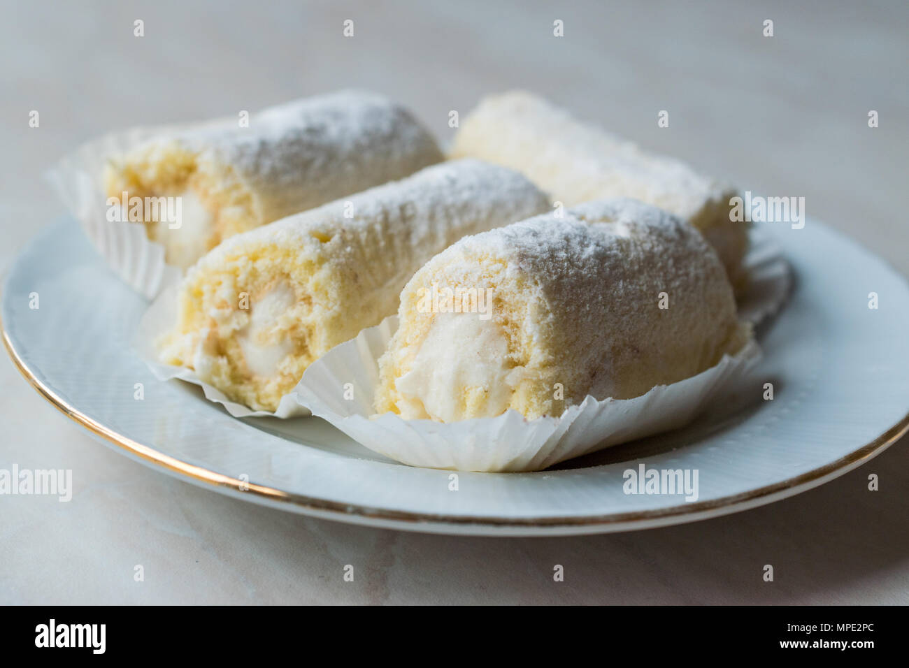 Rouleau Mini Gâteau à la crème de vanille, noix de coco et de sucre en poudre. Concept de dessert. Banque D'Images