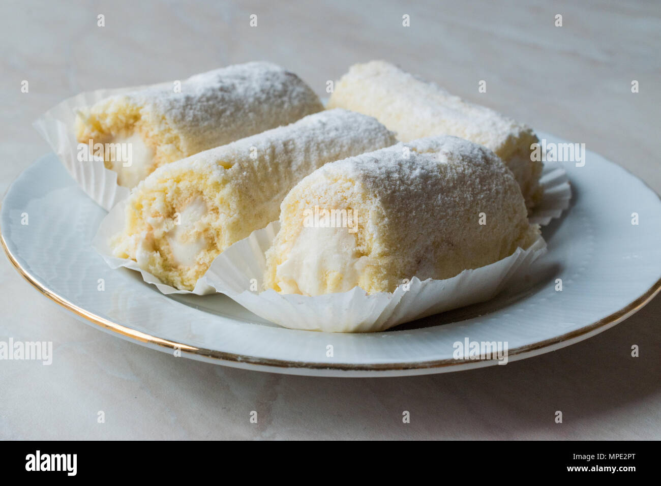 Rouleau Mini Gâteau à la crème de vanille, noix de coco et de sucre en poudre. Concept de dessert. Banque D'Images
