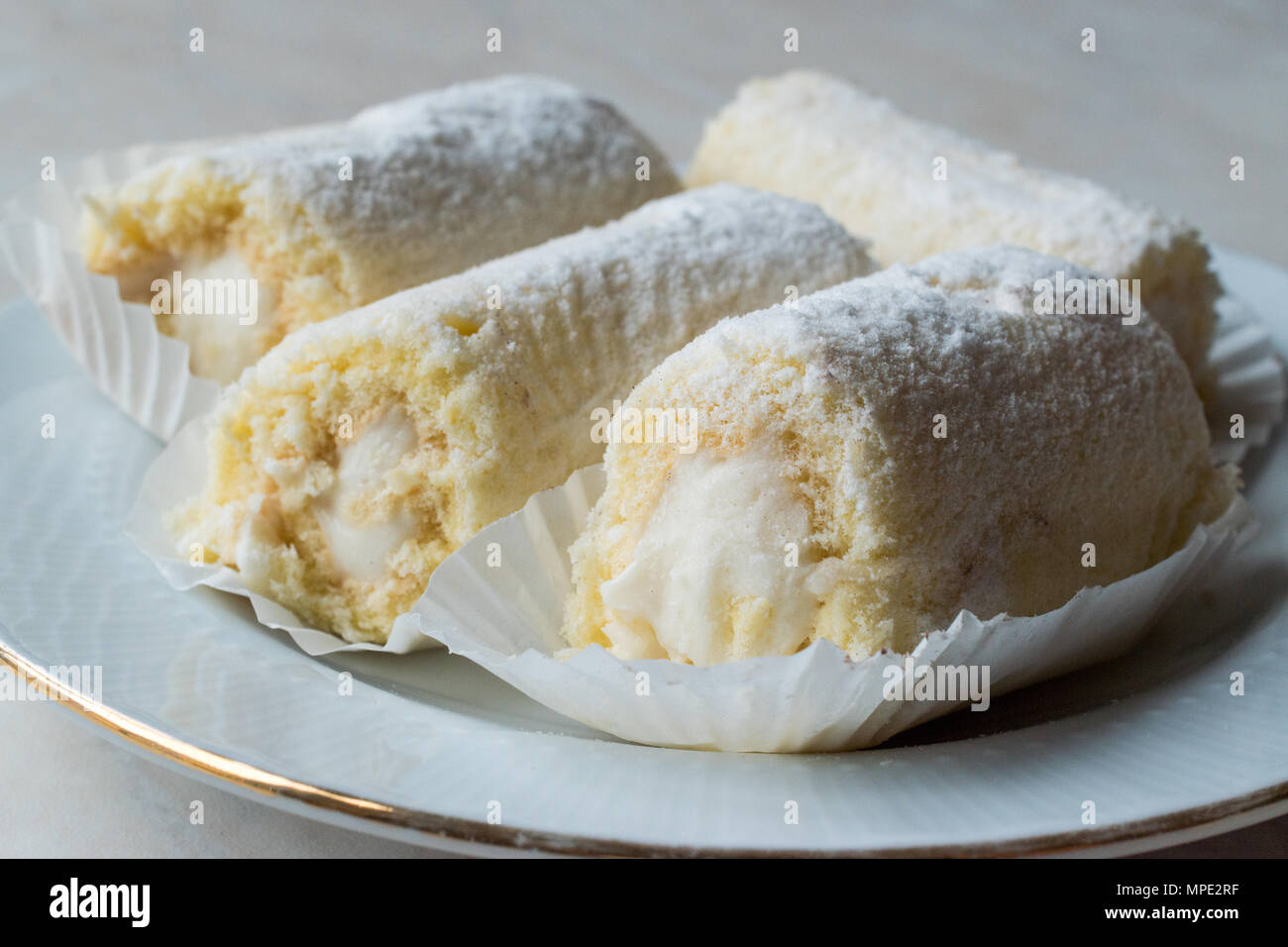 Rouleau Mini Gâteau à la crème de vanille, noix de coco et de sucre en poudre. Concept de dessert. Banque D'Images