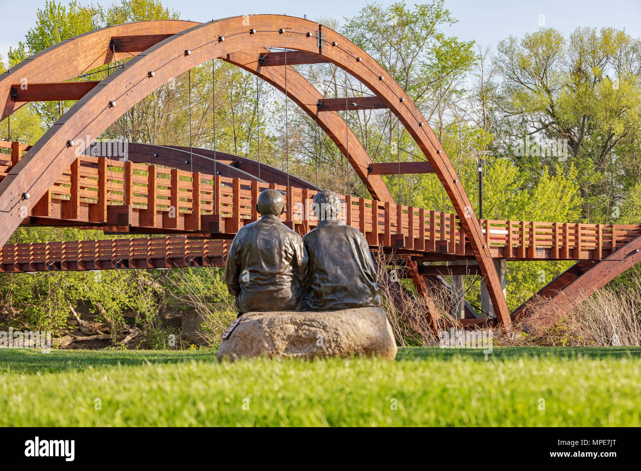 Le tridge couvre la confluence des rivières Chippewa et Tittabawassee dans le parc Chippewassee à Midland, Michigan. Couple Sculpture en premier plan Banque D'Images