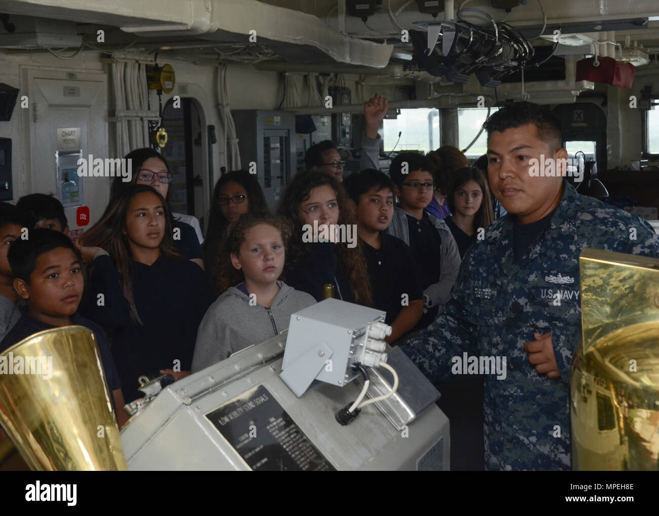 SANTA RITA, Guam (fév. 16, 2017) - Maître de Manœuvre 1re classe Francisco Fuenteshernandez, attribué à l'offre Câble sous-marin USS Frank (40), répond aux questions des enfants de McCool Middle School, sur la passerelle du navire au cours d'une visite, le 16 février. Frank, l'avant déployés dans l'île de Guam, procède à l'entretien et du soutien des sous-marins et navires de surface déployés aux États-Unis 5e et 7e flotte zone d'opérations. (U.S. Photo par marine Spécialiste de la communication de masse 3 Classe Josh Coté/libérés) Banque D'Images