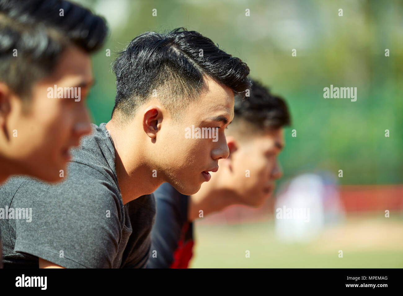 Close-up de visages de jeunes coureurs adultes asiatiques sur ligne de départ. Banque D'Images