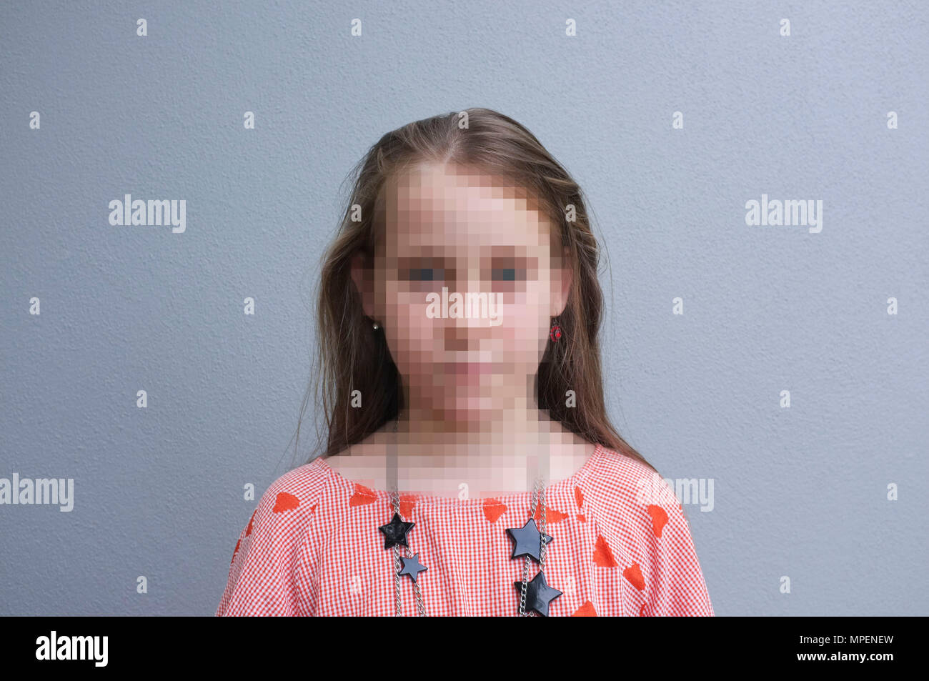 Portrait d'une fille contre un mur gris, avec son visage concept PIBR pixélisé Banque D'Images