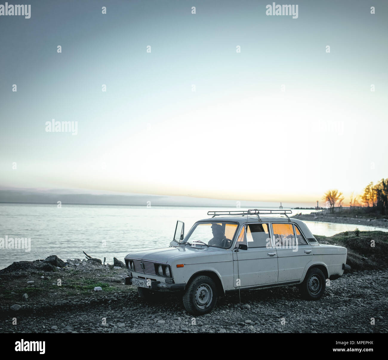 Homme dans la voiture sur la plage, Okhamchira, Abkhazie, Géorgie Banque D'Images