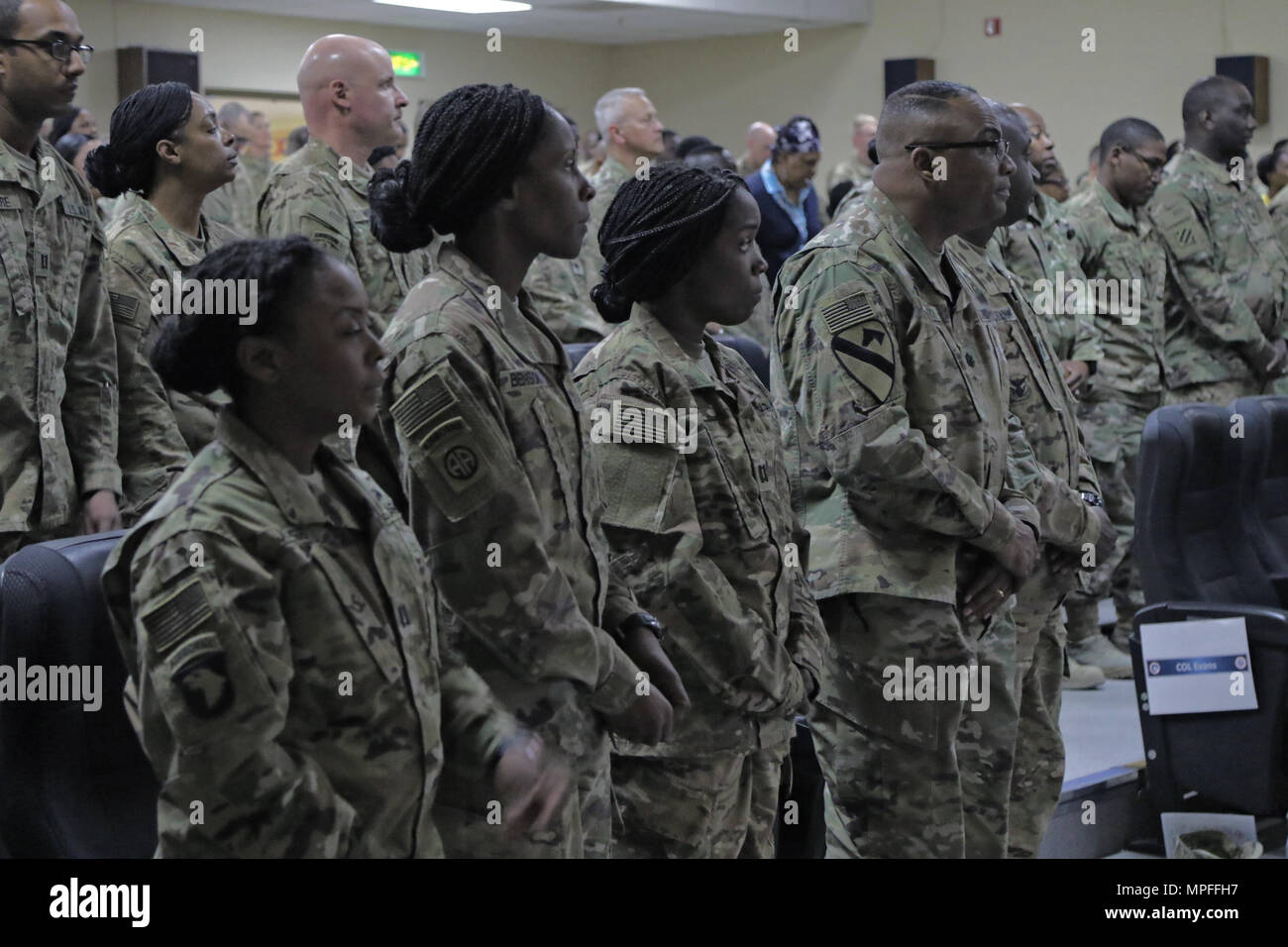 Soldats et civils résidant sur Camp Arifjan écouter intensément à l'invocation au cours de la célébration du Mois de l'histoire des Noirs dans le moral, de loisirs et de bien-être, Théâtre 22 février 2017, Camp Arifjan, au Koweït. La célébration comprenait le colonel conférencier Jeffery Carter, l'actuel vice-commandant de la 316e Commandement de soutien expéditionnaire, et d'un sketch historique appelé "Black History Month Cession." (U.S. Photo de l'armée par le Sgt. Bethany Huff, USARCENT) Affaires publiques Banque D'Images