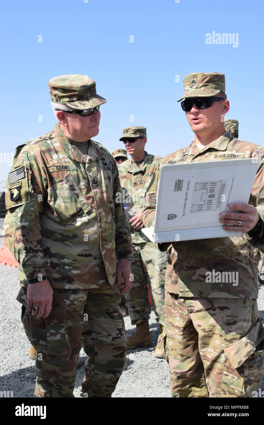 Le s.. Jacob Reckner avec la 207e compagnie de construction horizontale, droite, montre les détails d'un projet site à Brigue. Le général Benjamin Adams III du Kentucky, Directeur de l'état-major interarmées, le 4 mars au Camp Arifjan, au Koweït. Banque D'Images